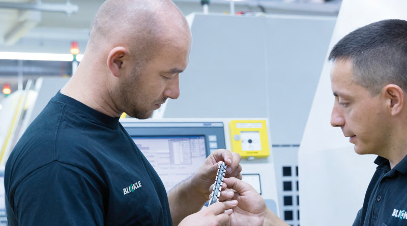 Ausbilder und Auszubildender prüfen ein Werkstück